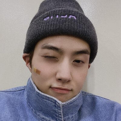 yeo changgu (better known by his stage name, "yeo one") from pentagon with a bandaid on his cheek and, wearing a beanie, winking (blue theme)